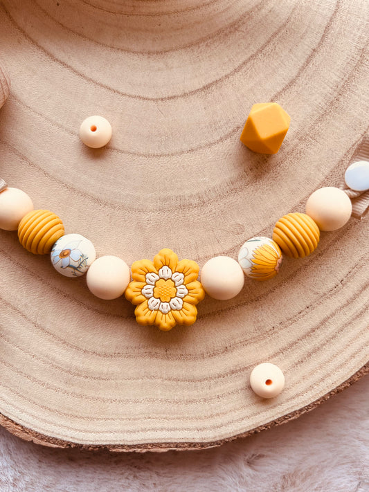 Attache tétine fleur moutarde