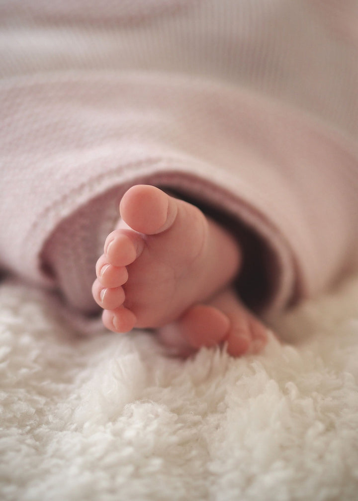 Petits pieds de nouveau-né blotti dans une couverture douce – prénoms basques pour bébé, fille et garçon