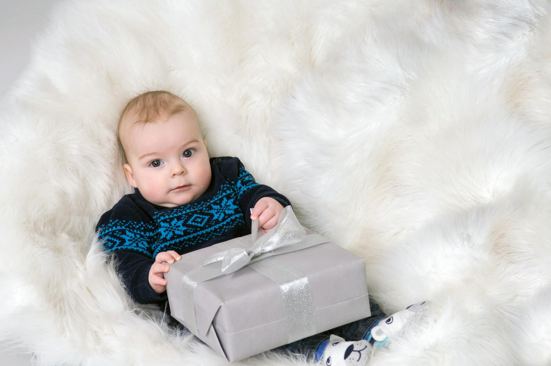 a baby in a sweater with a present