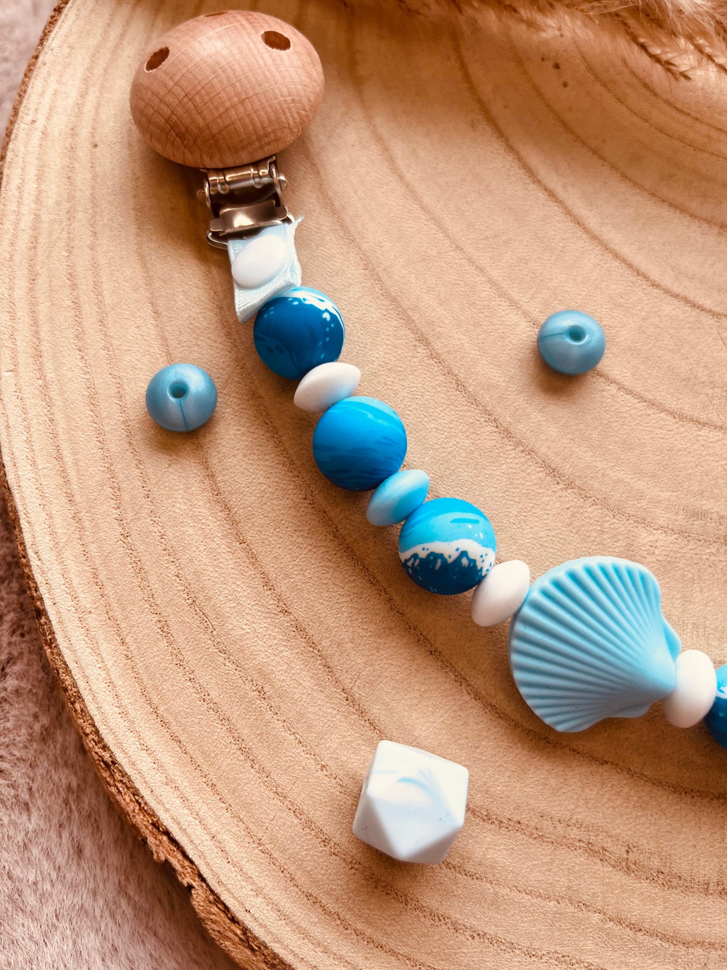 Détail du pendentif coquillage de l'attache tétine personnalisée bleue