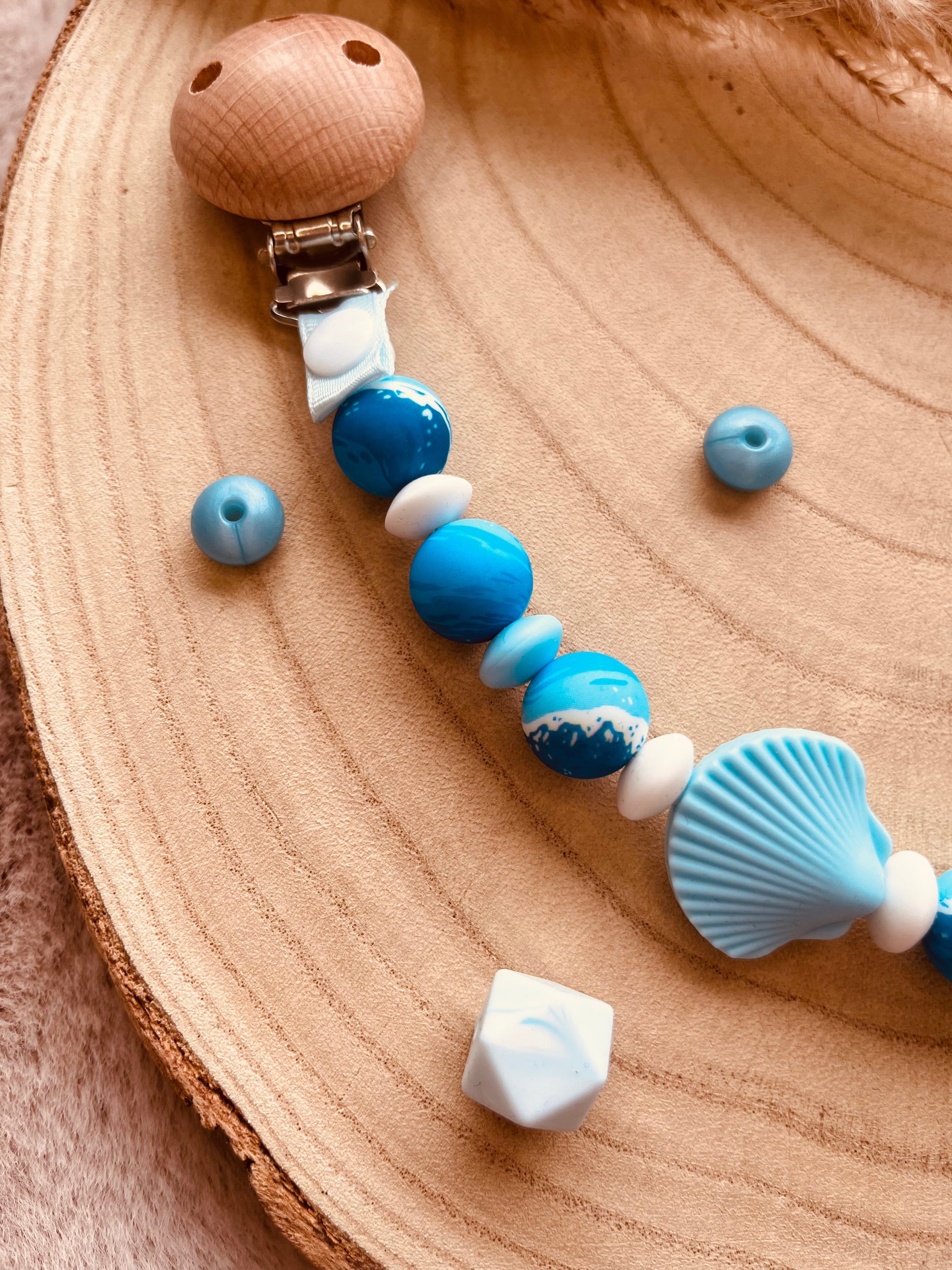 Détail du pendentif coquillage de l'attache tétine personnalisée bleue
