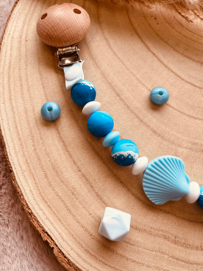 Détail du pendentif coquillage de l'attache tétine personnalisée bleue