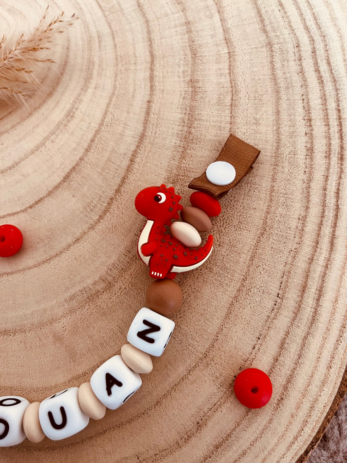 Attache-tétine personnalisée dinosaure rouge