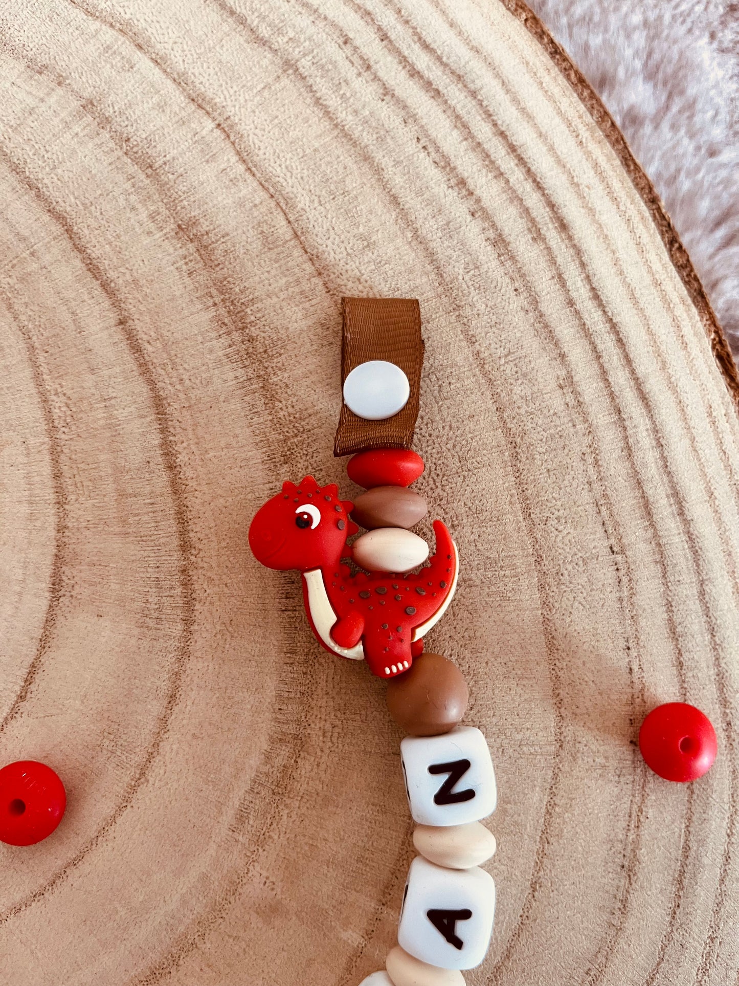 Attache-tétine personnalisée dinosaure rouge