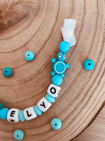 Turquoise schildpadfacifier bevestigt